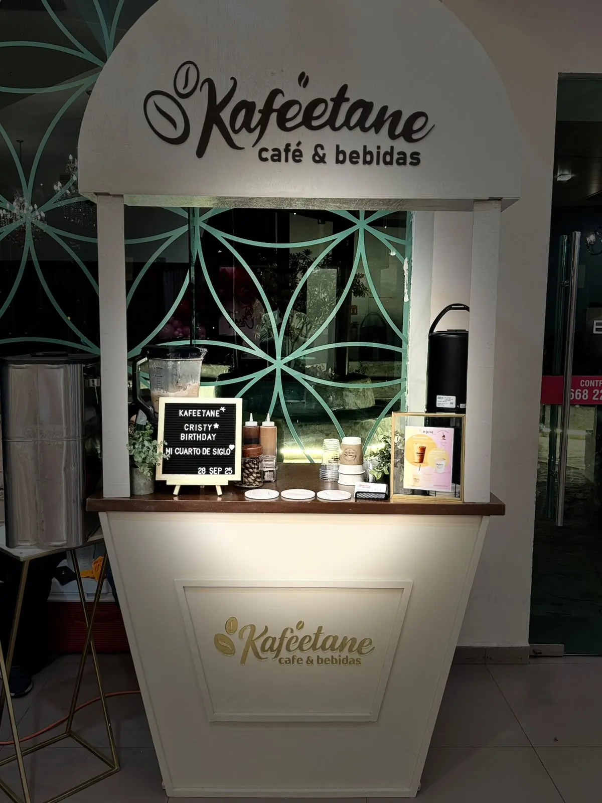 Carrito blanco de Kaféetane con techo de arco y logo iluminado, listo para servir en un evento